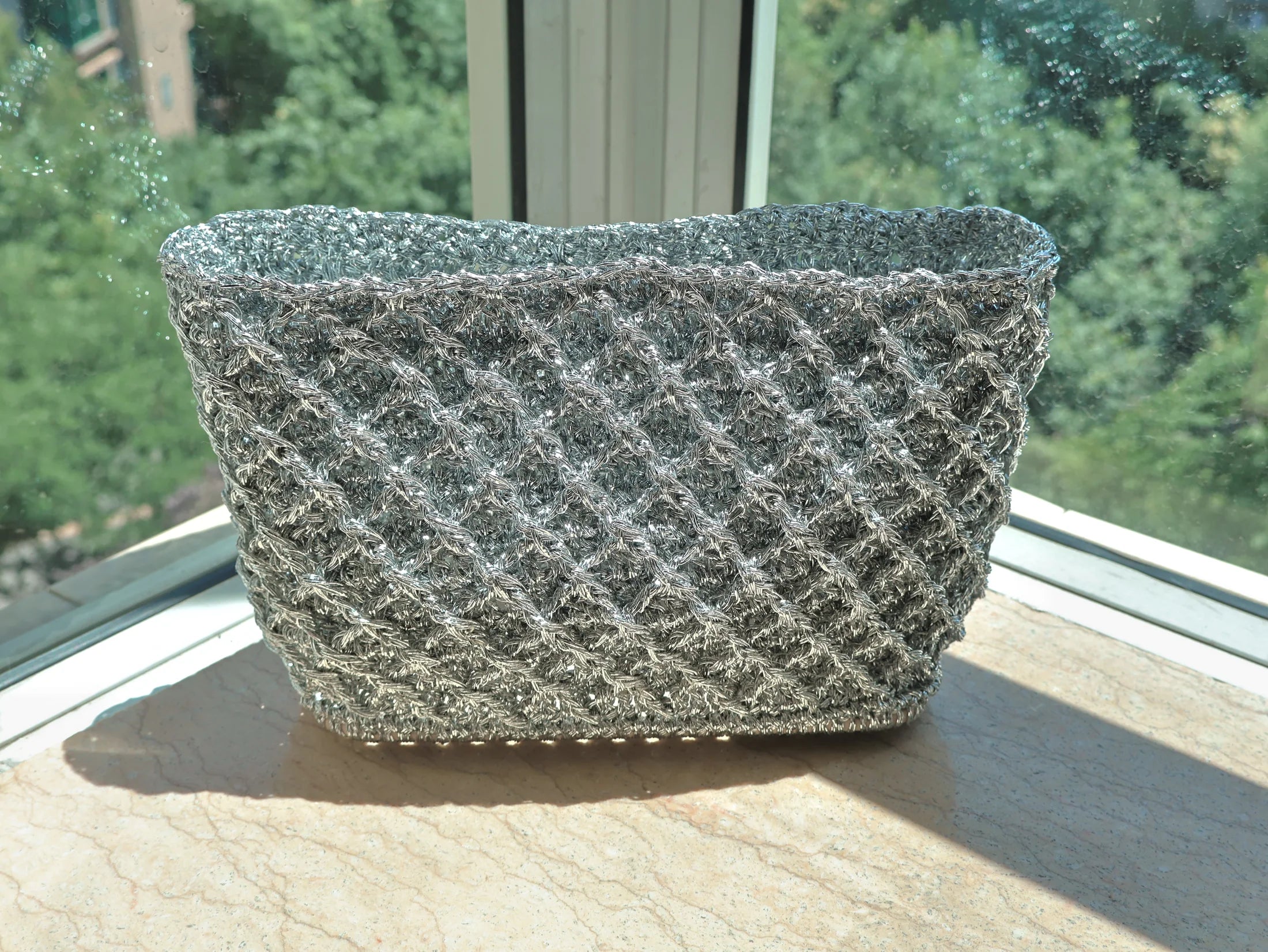 Silver hand-knitted lattice bag in sunlight