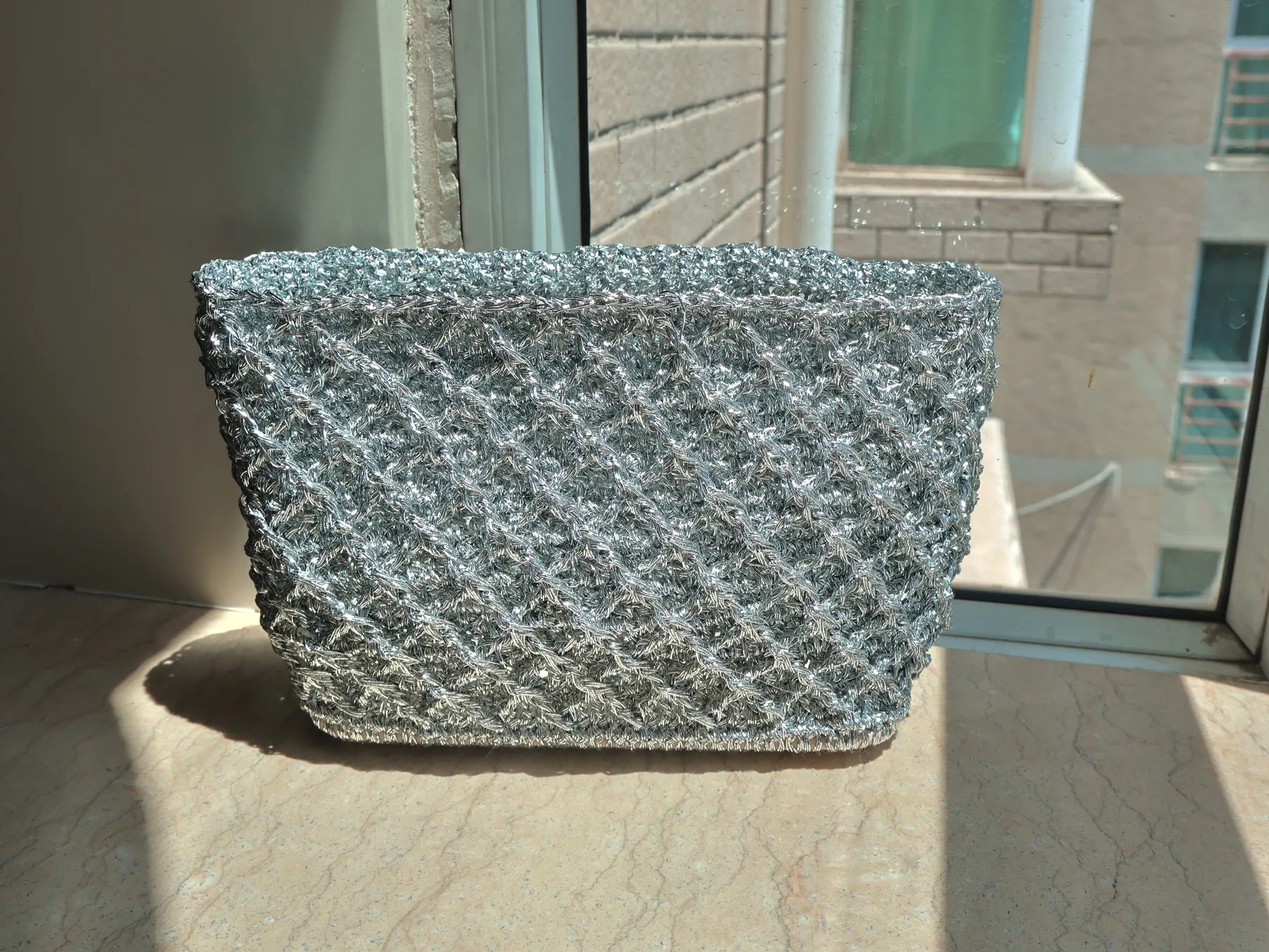 Silver lattice bag photographed in soft window light