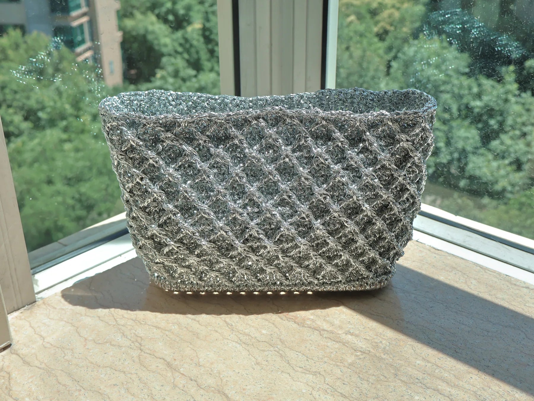 Silver lattice bag on a bright windowsill